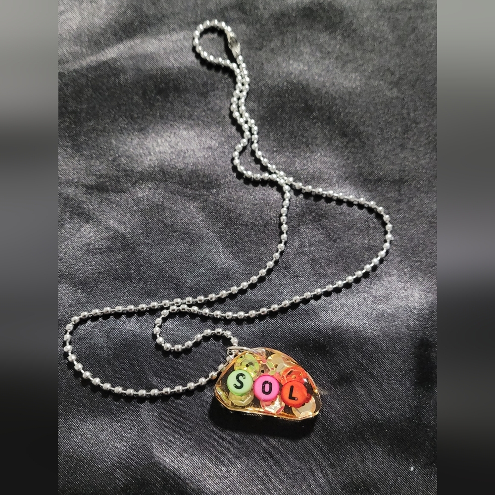 necklace with a pendant that says sol
